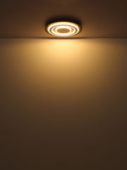 Moderne Deckenleuchte mit kreisförmigem Design, von unten betrachtet, leuchtet warmes Licht ausstrahlend.