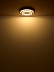 Moderne Deckenleuchte mit kreisförmigem Design, von unten betrachtet, leuchtet warmes Licht ausstrahlend.