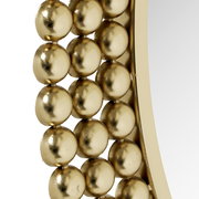 Nahaufnahme eines runden Spiegels mit einem Rahmen aus goldenen Kugeln, seitliche Perspektive.