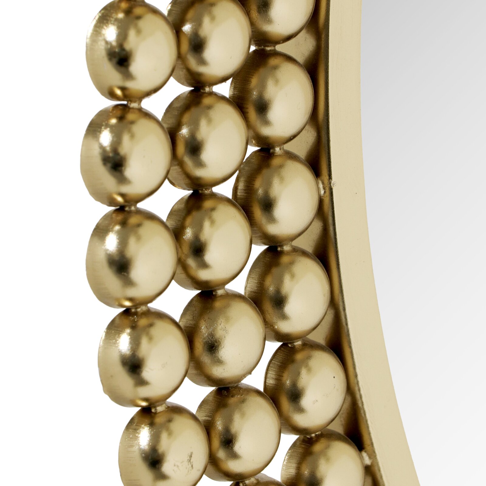 Nahaufnahme eines runden Spiegels mit einem Rahmen aus goldenen Kugeln, seitliche Perspektive.