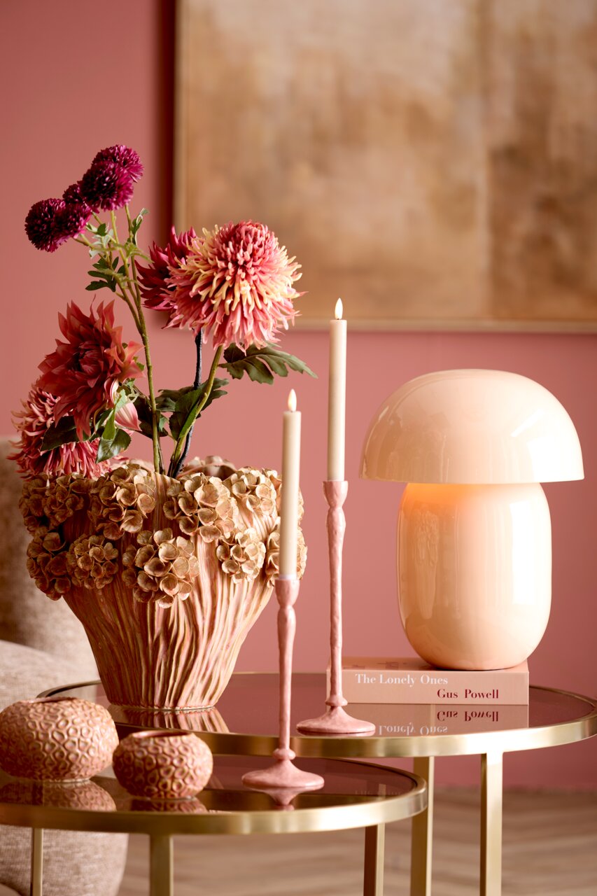 Elegante tafellamp in zachtroze op een gouden tafel, omringd door bloemen en kaarsen, zijaanzicht.