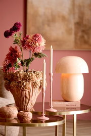 Elegante tafellamp in zachtroze op een gouden tafel, omringd door bloemen en kaarsen, zijaanzicht.