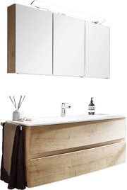 Moderne Badkombination mit Holzoptik, bestehend aus einem Waschtisch mit zwei Schubladen und einem dreitürigen Spiegelschrank, seitliche Perspektive.