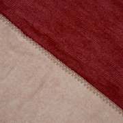 Nahaufnahme einer zweifarbigen Decke in Rot und Beige mit sichtbarer Naht, von oben betrachtet.