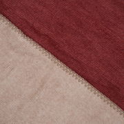 Nahaufnahme einer zweifarbigen Decke in Rot und Beige mit sichtbarer Naht, von oben betrachtet.