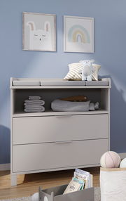 Wickelaufsatz schmal auf einer Kommode, mit Stofftieren und Handtüchern dekoriert, aus der Frontalperspektive.