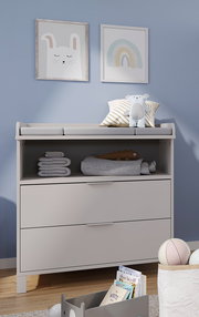 Wickelaufsatz schmal auf einer Kommode, mit Stofftieren und Handtüchern dekoriert, aus der Frontalperspektive.