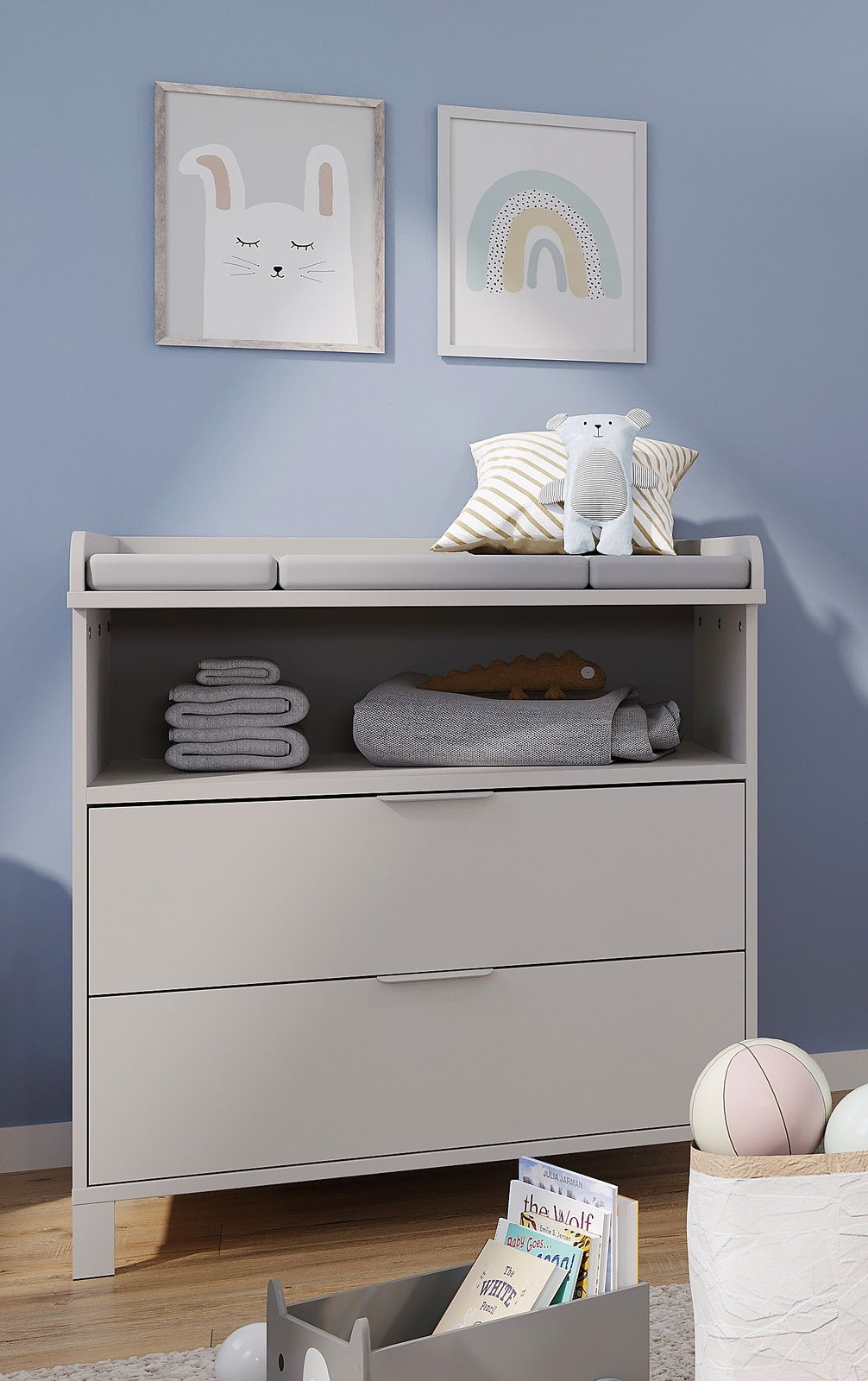 Wickelaufsatz schmal auf einer Kommode, mit Stofftieren und Handtüchern dekoriert, aus der Frontalperspektive.