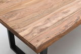 Nahaufnahme eines Esstisches aus Holz mit natürlicher Maserung und schwarzen Metallbeinen, Perspektive von oben.