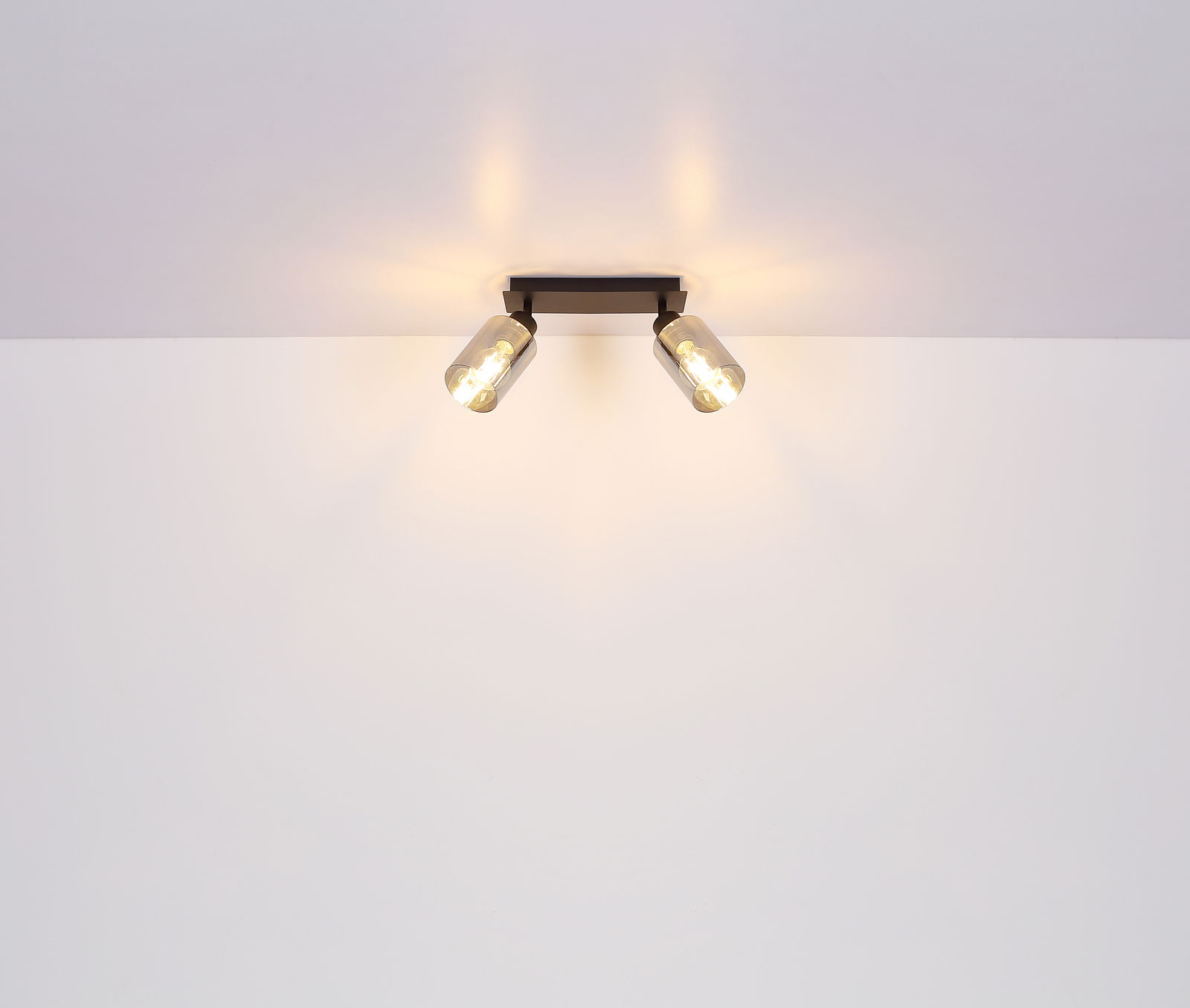 Zweiflammiger Strahler aus schwarzem Metall, matt, an der Decke montiert, mit warmem Licht, seitliche Perspektive.