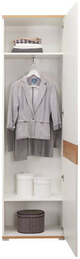 Offener Garderobenschrank mit hängendem grauen Blazer, gefalteten Decken und dekorativen Boxen, Frontalansicht.