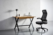Moderner Drehstuhl in Schwarz mit ergonomischem Design, seitliche Perspektive neben einem Schreibtisch.