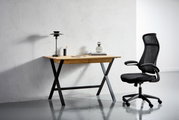 Moderner Drehstuhl in Schwarz mit ergonomischem Design, seitliche Perspektive neben einem Schreibtisch.
