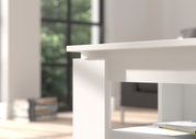 Nahaufnahme eines weißen Couchtisches mit modernem Design, seitliche Perspektive, im Hintergrund ein Fenster mit Blick ins Grüne.