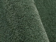 Nahaufnahme eines grünen Uni-Teppichs mit weicher Textur und leicht gewellter Oberfläche.