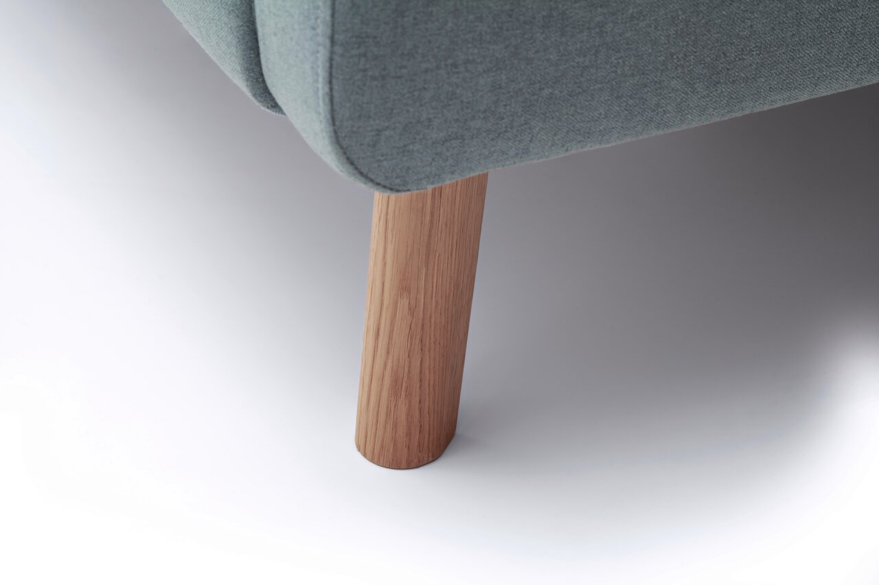 Nahaufnahme eines Polsterbettbeins aus Holz mit grauem Stoffbezug, seitliche Perspektive