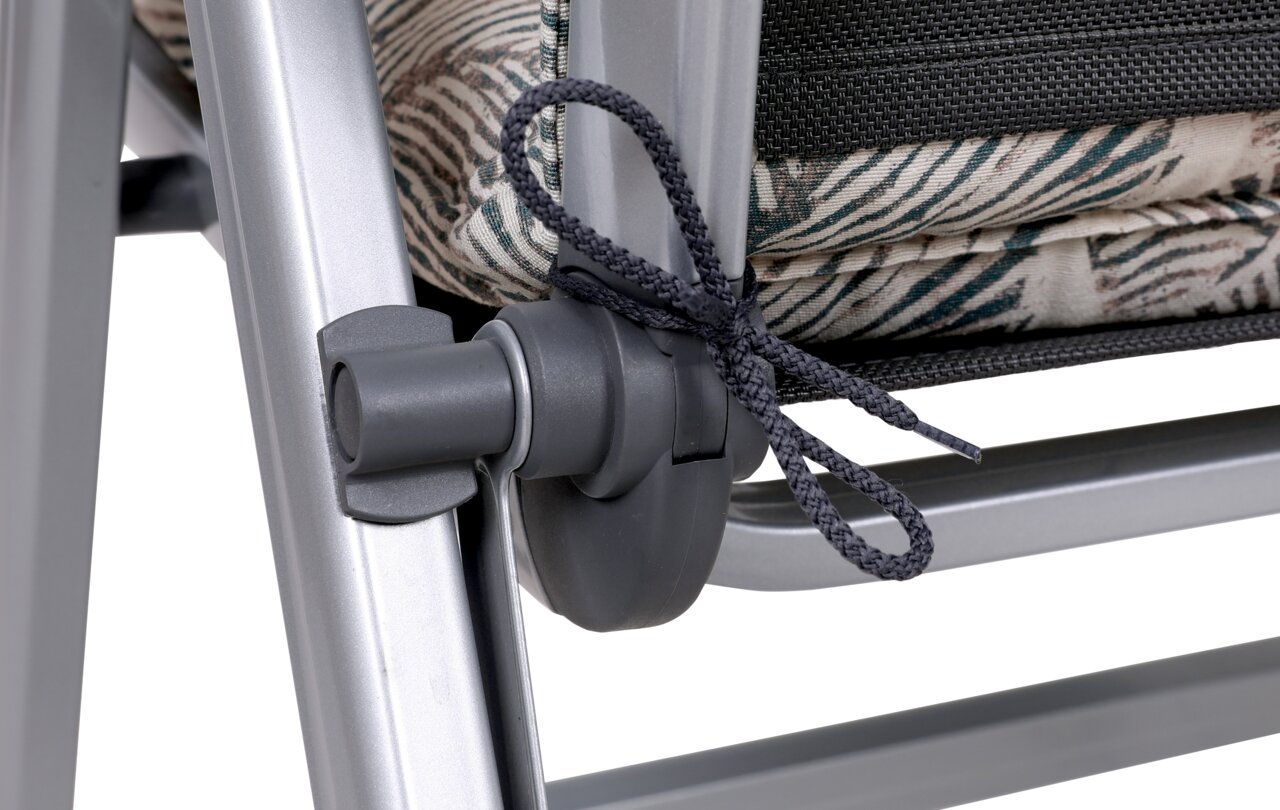 Go-De Stoelbekleding Close-up van een fauteuilbekleding met tropisch patroon, bevestigd aan een metalen frame. Zijaanzicht.