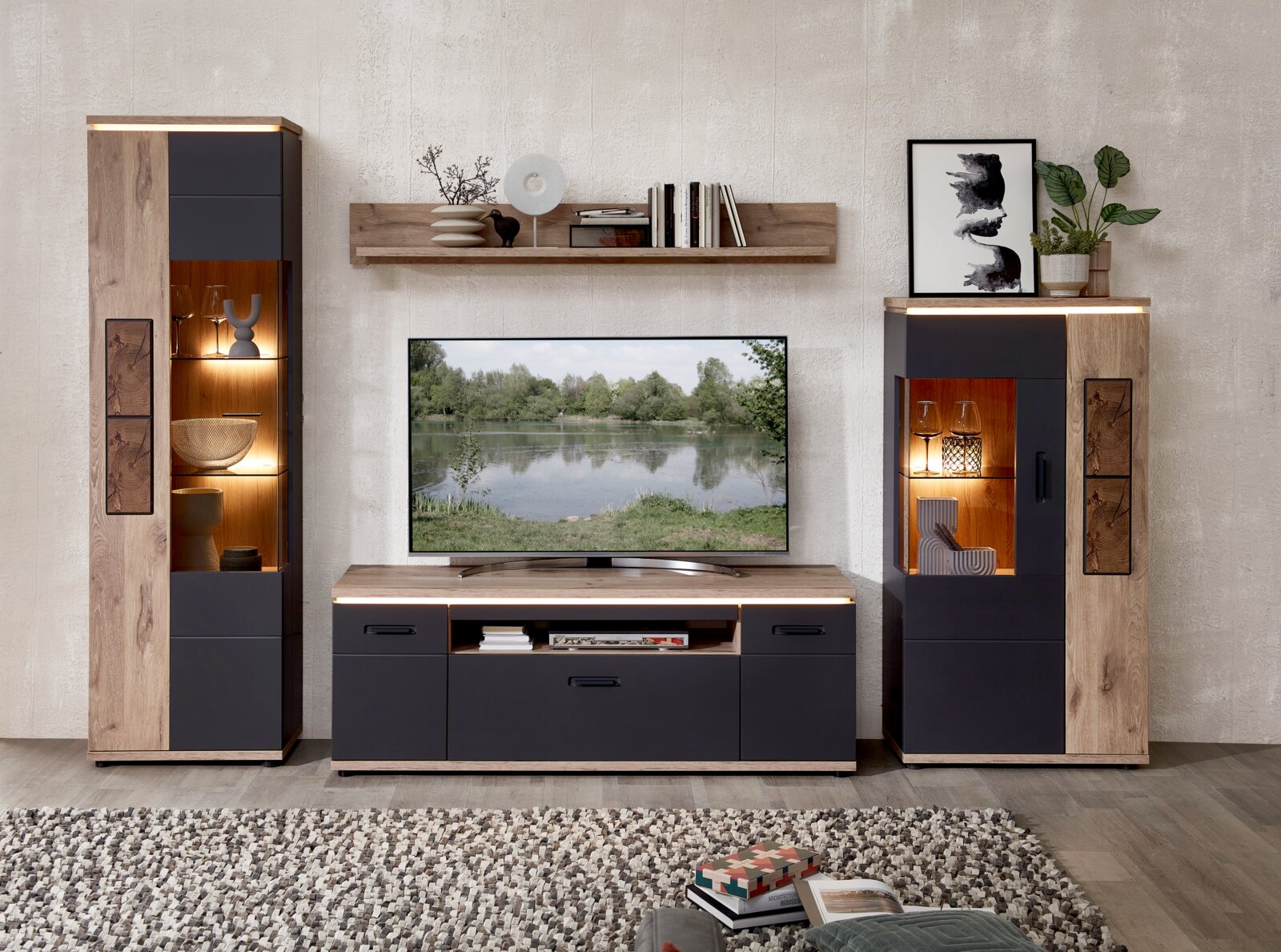 Stylife Wandkombination SINA Frontale Ansicht einer modernen Wohnwand im Wohnzimmer: TV-Lowboard mit Fernseher, zwei Vitrinenschränke und Wandregal in Holzoptik und Anthrazit mit integrierter LED-Beleuchtung.