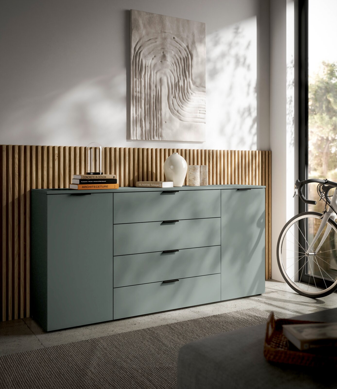 Modernes XL-Sideboard in einem stilvollen Raum, seitliche Perspektive mit Dekorationen und einem Fahrrad im Hintergrund.