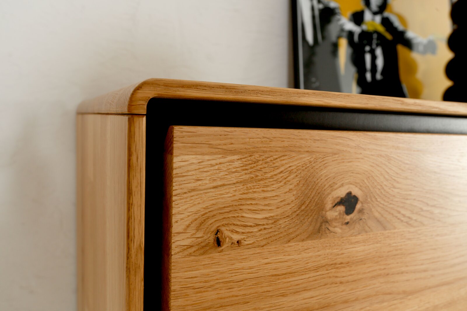 Landscape Wandcombinatie BRIXEN Close-up van de linkerbovenhoek van een bedframe van massief hout (eiken) met zichtbare nerf en knoest, licht schuin van voren gefotografeerd.