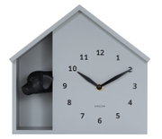 Moderne wandklok in de vorm van een huis met een zwarte hondenkop, van voren afgebeeld.
