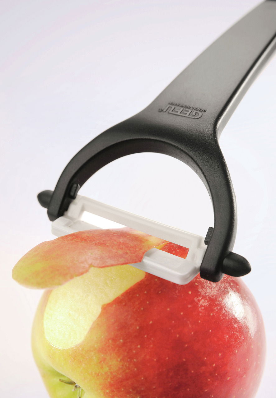 Keramikschäler Ceramo in Nahaufnahme, der die Schale eines Apfels entfernt.