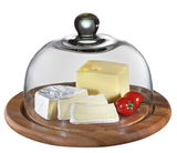 Käseglocke mit Glasdeckel auf Holzplatte, gefüllt mit verschiedenen Käsesorten und Tomaten, seitliche Perspektive