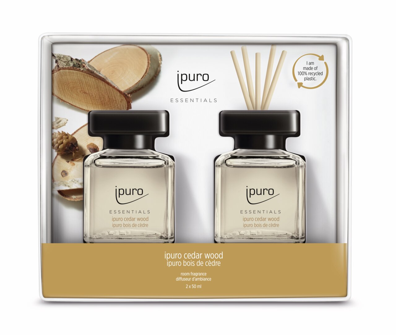 Zwei Flaschen Cedar Wood Raumduft von ipuro in einer Verpackung mit Holzscheiben im Hintergrund, Vorderansicht.