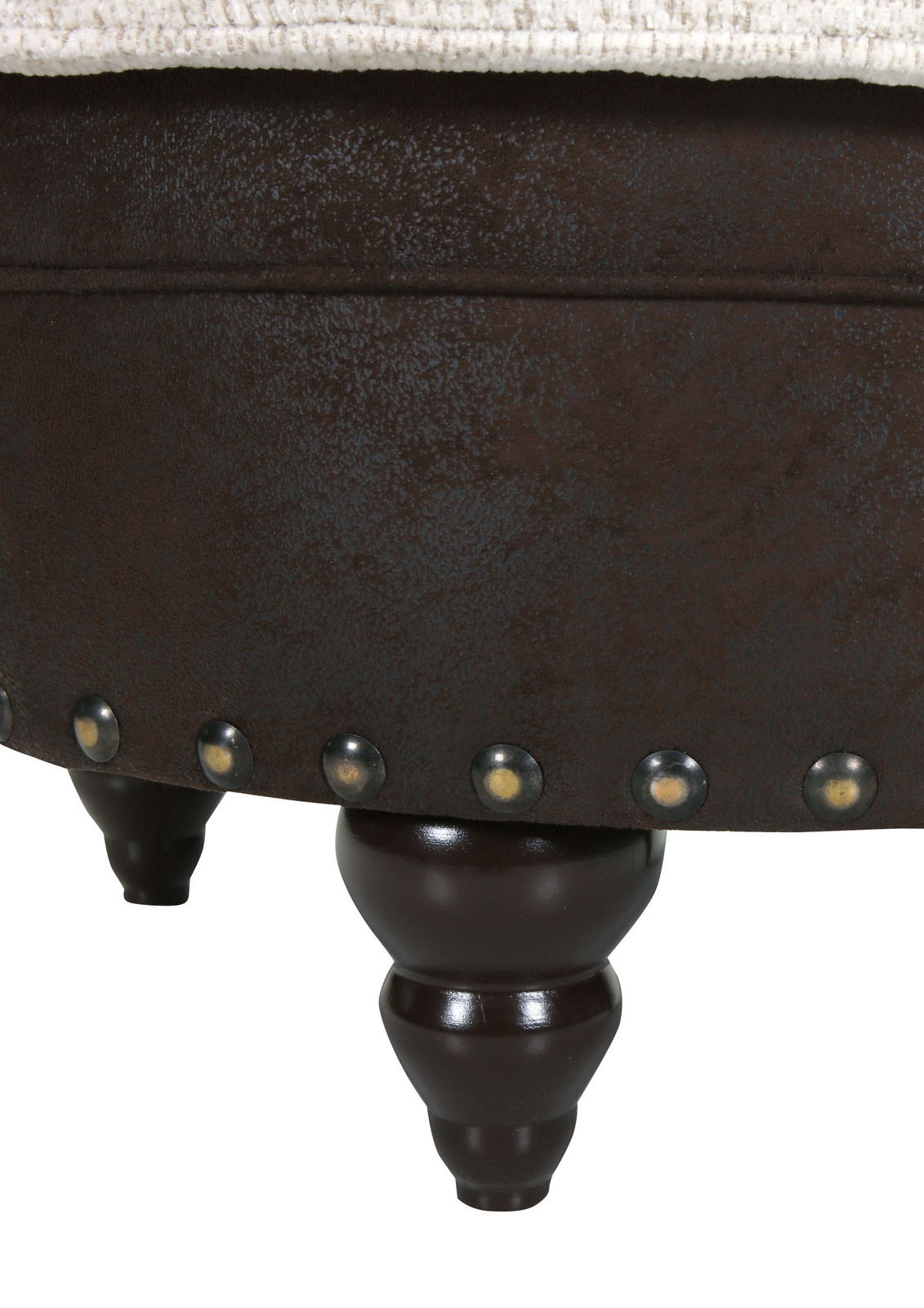 Nahaufnahme eines Hockers mit dunklen Holzbeinen und dekorativen Nieten, seitliche Perspektive.