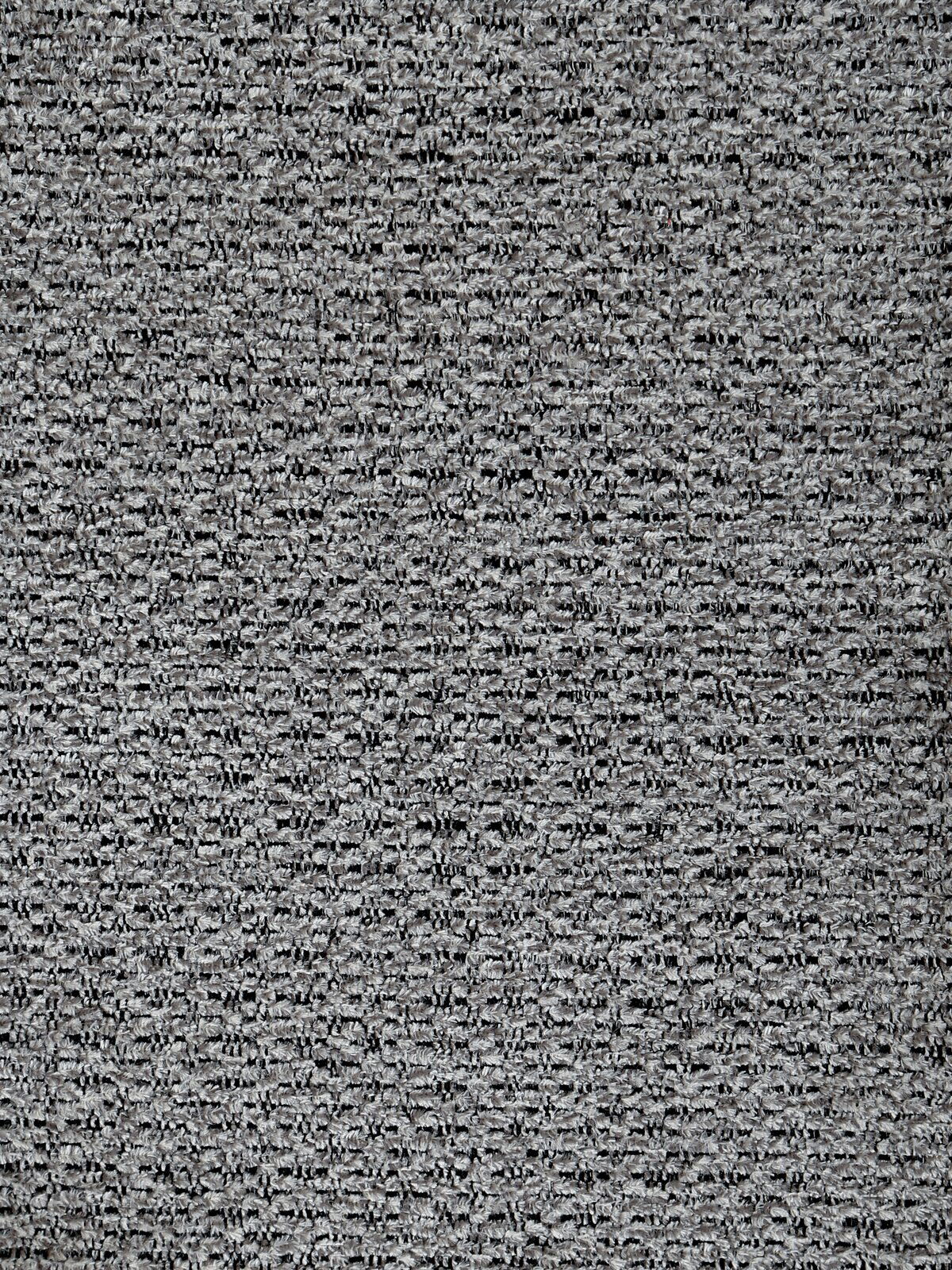 Nahaufnahme eines grauen Stoffmusters, das für einen Armlehnstuhl verwendet wird