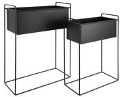 Zwei schwarze Pflanzgefäße in modernem Design, auf Metallgestellen stehend, aus seitlicher Perspektive fotografiert.