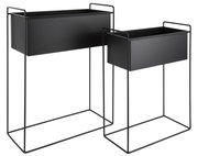 Zwei schwarze Pflanzgefäße in modernem Design, auf Metallgestellen stehend, aus seitlicher Perspektive fotografiert.