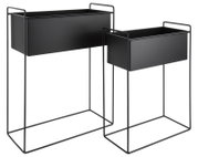 Zwei schwarze Pflanzgefäße in modernem Design, auf Metallgestellen stehend, aus seitlicher Perspektive fotografiert.
