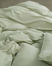 Grüne Bettwäsche 135x200cm aus der Vogelperspektive, weich und einladend drapiert.