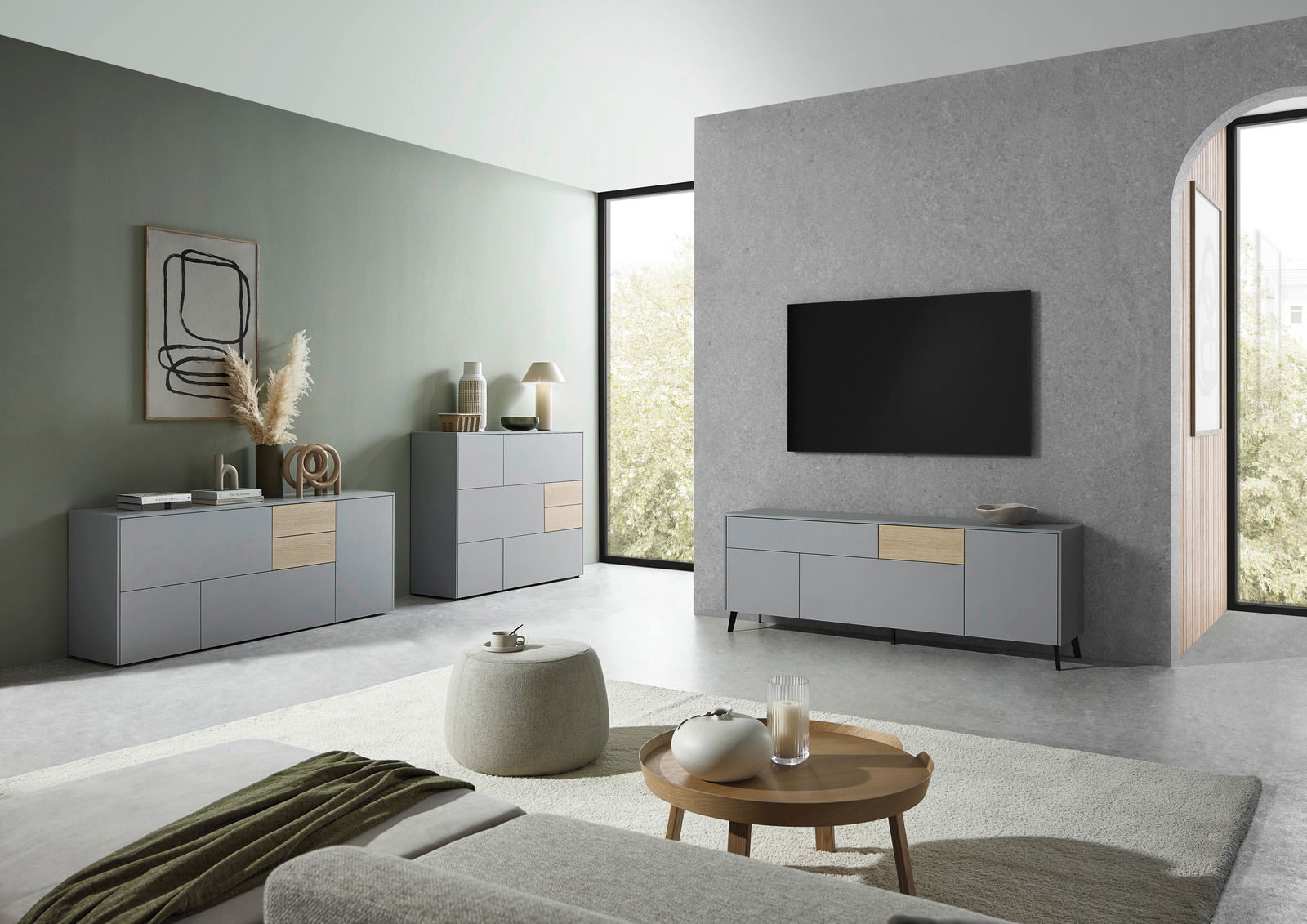 Modernes Wohnzimmer mit grauem TV-Lowboard, Sideboard und Highboard in minimalistischer Einrichtung, seitliche Perspektive.
