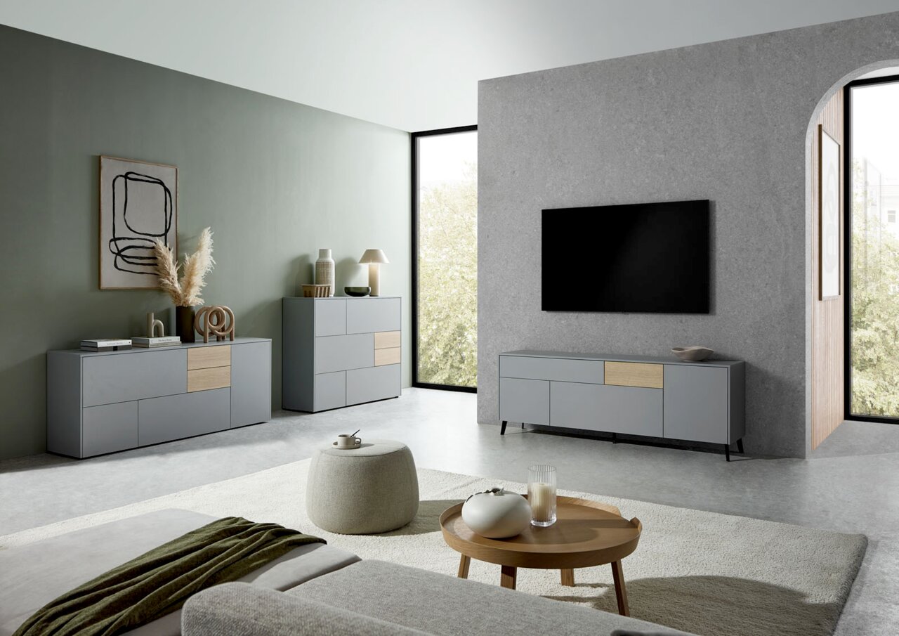 Modernes Wohnzimmer mit grauem TV-Lowboard, Sideboard und Highboard in minimalistischer Einrichtung, seitliche Perspektive.