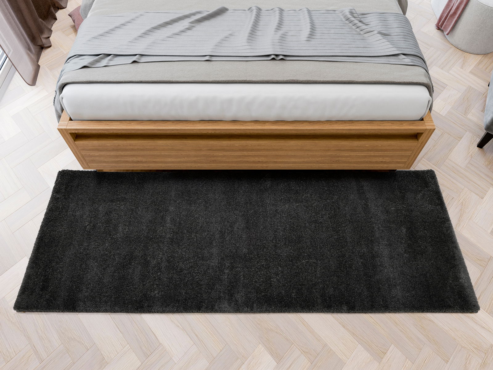 Schwarzer Hochflor-Teppich vor einem Bett aus Holz, Vogelperspektive