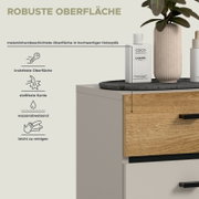 Nahaufnahme in frontaler Seitenansicht eines Badmöbels/Waschtischunterschranks in Weiß mit Holzoptik-Schubladenfront und schwarzem Griff; Textgrafik bewirbt melaminharzbeschichtete, robuste Oberfläche (kratzfest, stoßfeste Kante, wasserabweisend, leicht z