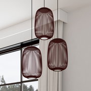 Drei moderne Pendelleuchten mit dunkelrotem, ovalem Draht-Lampenschirm hängen in einem hellen Raum vor Fenster und Vorhang, Ansicht leicht von unten (Untersicht).