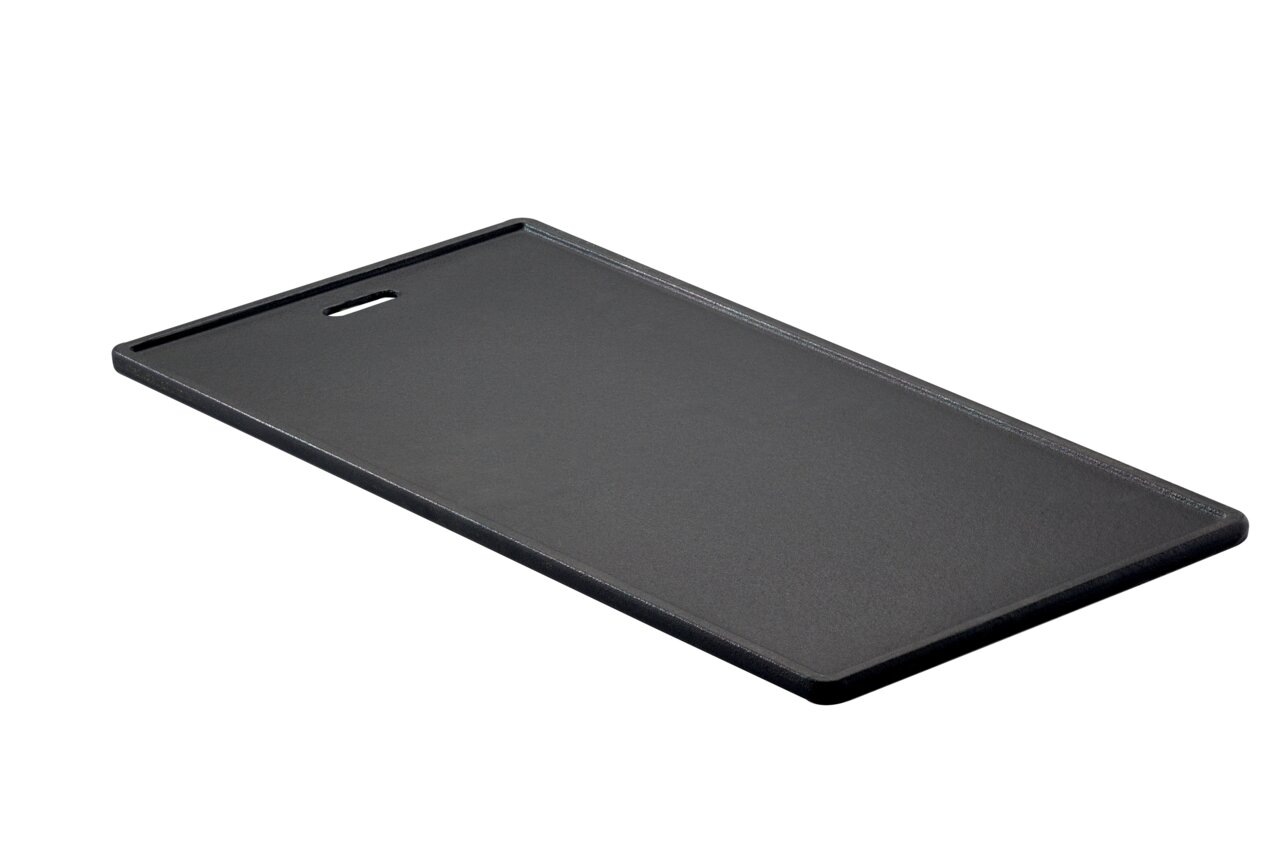 Schwarze Grillplatte aus Gusseisen mit glatter Oberfläche, schräg von oben fotografiert.