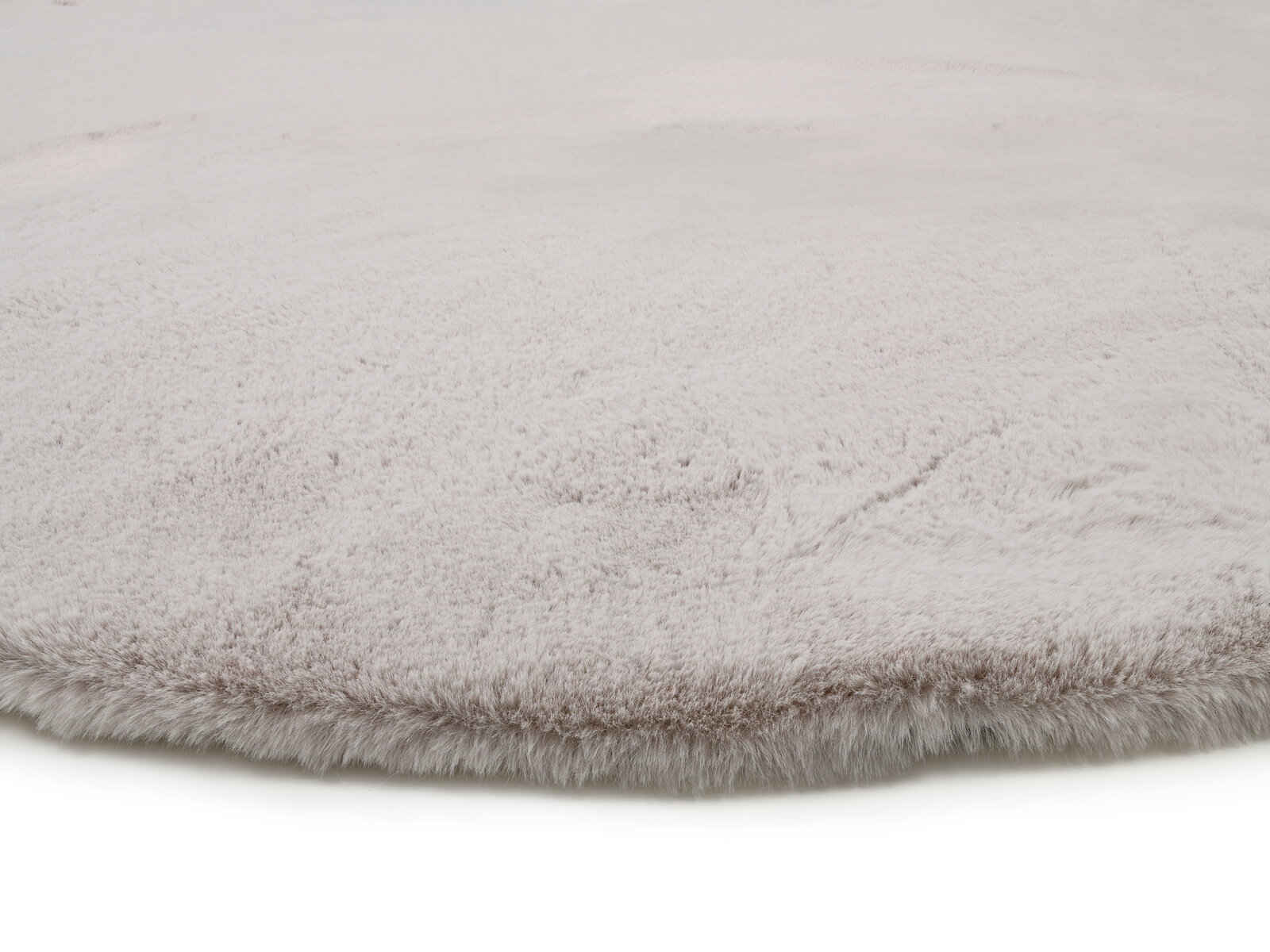 Nahaufnahme eines weichen, hellgrauen Fellteppichs mit flauschiger Textur.