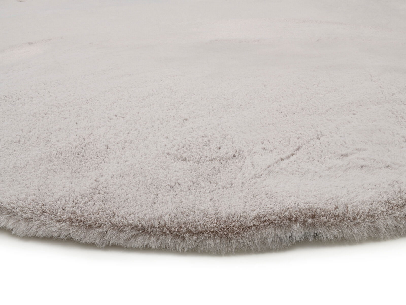 Nahaufnahme eines weichen, hellgrauen Fellteppichs mit flauschiger Textur.