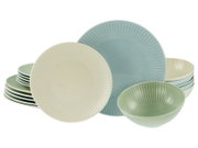 Pastellfarbenes Geschirrset mit geriffelten Tellern und Schalen in Creme, Hellblau und Grün, frontal in leicht schräger Perspektive vor weißem Hintergrund.