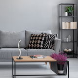 Moderne Tischleuchte Bridge auf einem Couchtisch in einem stilvollen Wohnzimmer, seitliche Perspektive.