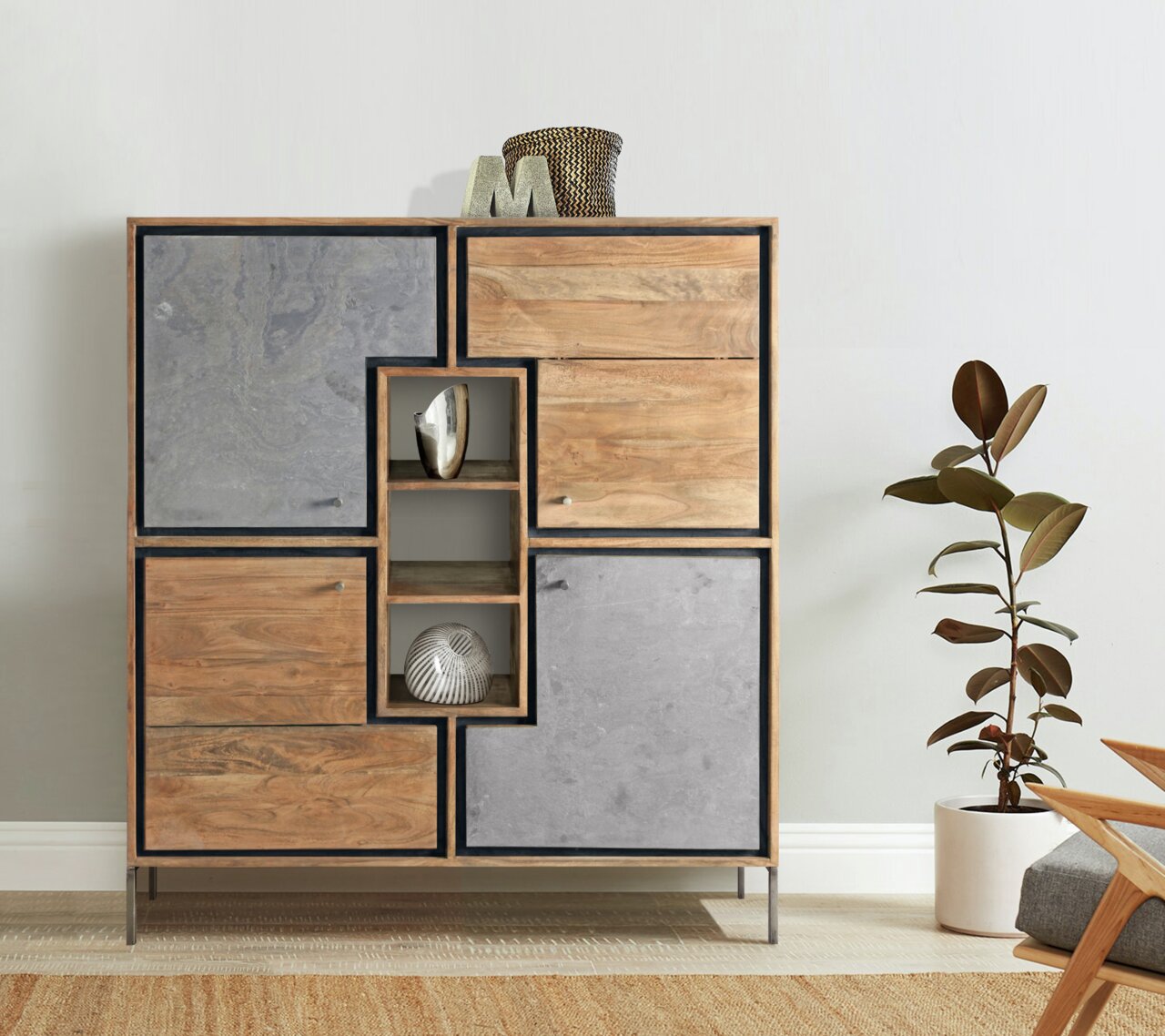 Modernes Highboard aus Holz und Betonoptik, frontal fotografiert, mit dekorativen Elementen und Pflanzen im Hintergrund.