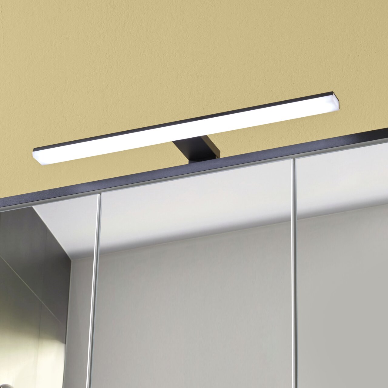 Moderne LED-Leuchte auf einem Spiegelschrank, frontal betrachtet.