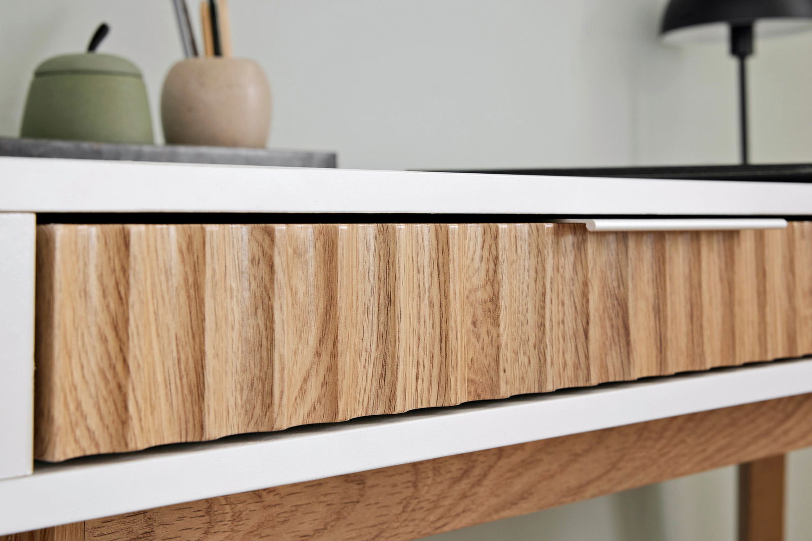 Nahaufnahme eines Schreibtisches mit Holzschublade und weißem Rahmen, seitliche Perspektive
