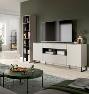 Modernes Wohnzimmer mit beigem TV-Lowboard auf schwarzen Metallfüßen und großem Fernseher, daneben hohes Regal; Aufnahme aus leicht schräger Frontperspektive.