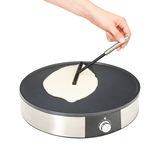 Crepes-Maker WMF LONO in seitlicher Perspektive mit Hand, die Teig auf der heißen Platte verteilt.