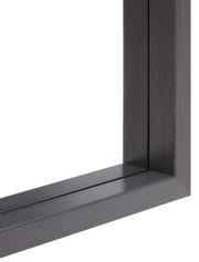 Nahaufnahme eines dunklen Holzrahmens eines Spiegels aus der Perspektive der unteren rechten Ecke.